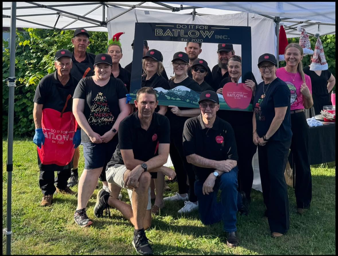 The Do It For Batlow crew gathered under the marquee at a Christmas community event